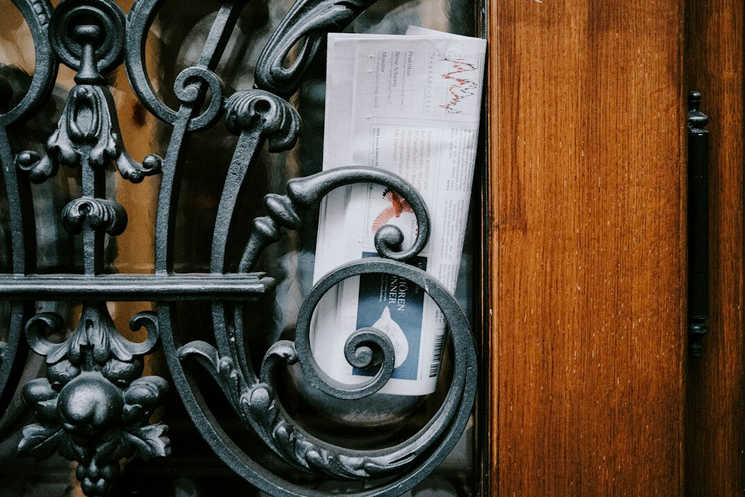 Stack of newspapers and broadcast notes on a newsroom desk